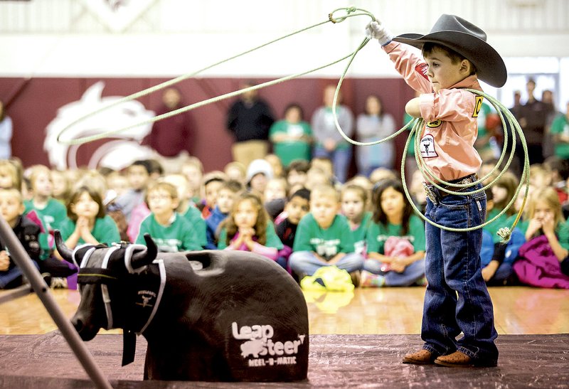 NWA Democrat-Gazette/JASON IVESTER Colton Workman, 5, demonstrates his calf-roping skills during an assembly Jan. 8 at the old Lincoln High School gym. Born with a shortened left arm, Colton has wowed the rodeo world with his talent. Now, he and his partner Stevie Ray Blackbird of Elm Springs have the chance to team rope against some of rodeo&#8217;s top athletes at the RFD-TV American Rodeo next month. Watch Colton in action at youtube.com/nwademgaz.