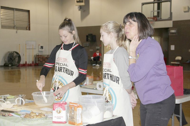 LYNN KUTTER ENTERPRISE-LEADER Eighth-graders Cambre Strange and Kalli Stout served as cooking assistants last week for Pam Jensen, a cooking instructor with King Arthur Flour Co., of Vermont. Jensen taught sixth- and seventh-graders at Lynch Middle School how to bake their own loaf of bread. Through the presentation, Jensen explained how math, science and reading are used in cooking and everyday life.
