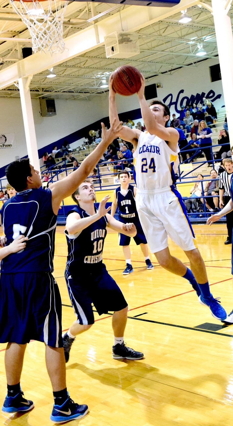 Photo by Mike Eckels Tyler Riddle (Decatur #24) goes up for a layup against Christian Snipes (Union Christian #10) and Jacob Jarvis (Union Christian #5) during the Bulldog-Eagle matchup at Peterson Gym in Decatur Jan. 26. The Eagles hand Decatur its fifth conference lose of the season, 48 to 31.