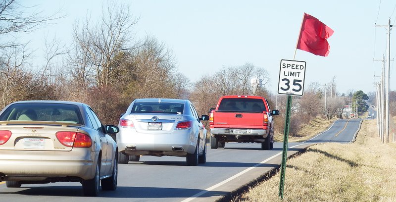 TIMES photograph by Annette Beard A red flag atop the speed limit sign just west of Miser Road on Lee Town Road signals the decreased speed limit. Lee Town Road is a short cut from Ark. Hwy. 72 adjacent to the Pea Ridge National Military Park to the south four-way stop in Pea Ridge where it rejoins Ark. Hwy. 72 which then turns west to continue to Bentonville.