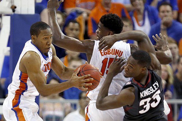 Florida guard KeVaughn Allen (4) grabs a rebound away from Arkansas forward Moses Kingsley (33) during the second half of an NCAA college basketball game at the O'Connell Center on Wednesday, Feb. 3, 2016 in Gainesville, Fla. Florida defeated Arkansas 87-83. (Matt Stamey/The Gainesville Sun via AP)