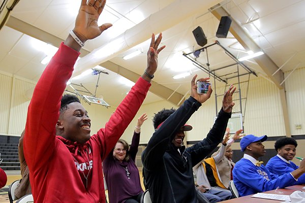 Pulaski Robinson's TJ Hammonds, calls the hogs with the crowd during a signing ceremony Wednesday at the Little Rock school. At right is classmate Tonda Bullock, who signed with Henderson State.