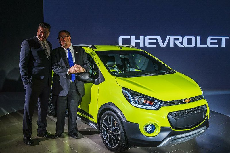 Attendees at the Auto Expo in Noida, Uttar Pradesh, in India stand Wednesday beside a Chevrolet Essentia, one of the new models that General Motors Co. is introducing for 2017. 