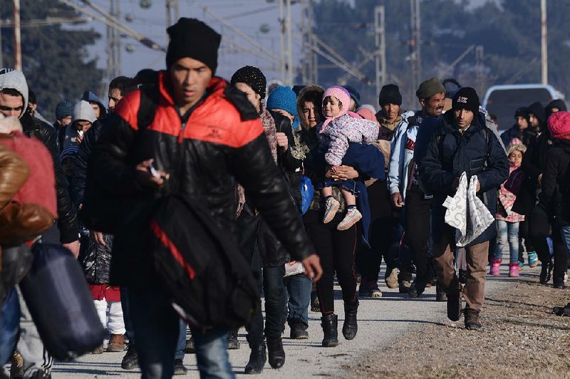 People walk to a refugee camp Wednesday as they wait to be allowed to continue their trip to southern Macedonia, near the northern Greek village of Idomeni. 
