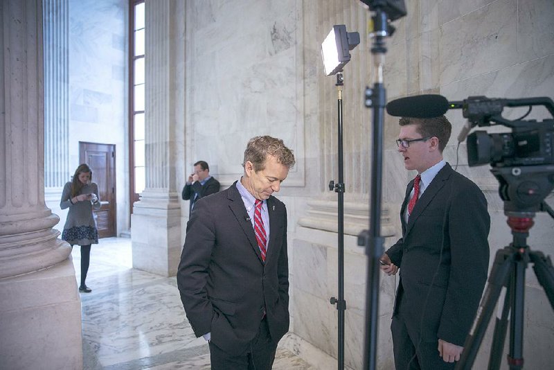 Rand Paul talks with a reporter Wednesday on Capitol Hill after announcing the end of his presidential campaign. 