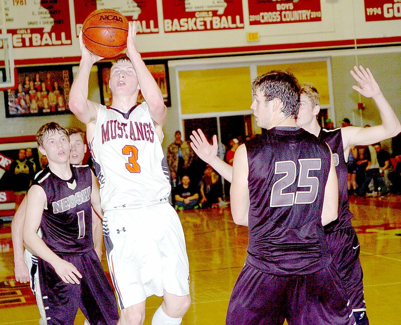 Photo by Rick Peck McDonald County&#8217;s Daton Aubrey and Neosho&#8217;s Coleman Scott get tangled up going for a rebound during the Mustangs&#8217; 57-54 win Friday night at MCHS.