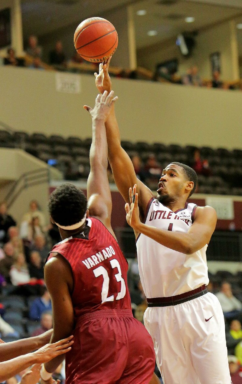 UALR forward Jalen Jackson (right) shoots over Troy defender Jordan Varnado during Thursday’s game at the Jack Stephens Center in Little Rock. Jackson scored 13 points to help the Trojans beat Troy 72-49. To see more photos of the game, visit arkansasonline.com/galleries.