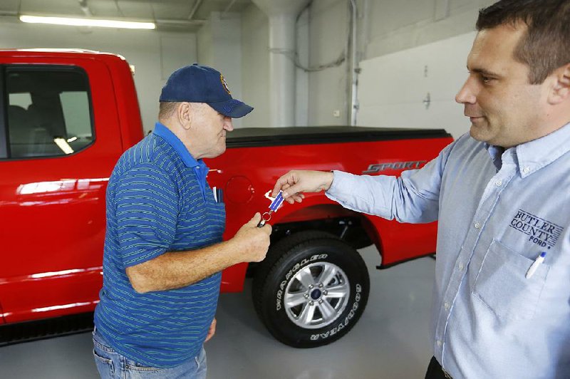 A salesman hands the keys to a 2015 Ford F-150 to its new owner at a Ford dealership in Butler, Pa., in November.