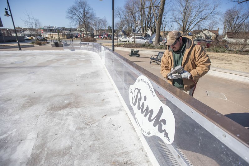 NWA Democrat-Gazette/J.T. WAMPLER Devin Strickland of Bentonville dismantles Thursday the wall around the Rink at Lawrence Plaza in Bentonville. The skating season starts in November and lasts through January. Strickland works for Bentonville Parks and Recreation department.