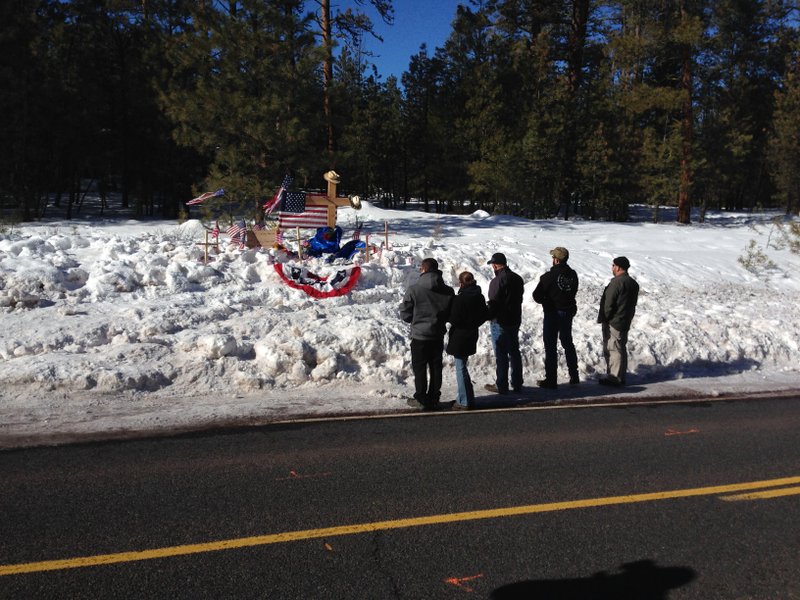 Mourners gather Sunday, Jan. 31, 2016, at roadside memorial for rancher LaVoy Finicum near Burns, Oregon. Finicum was killed Tuesday night in a confrontation with the FBI and Oregon State Police on a remote road. Four people still occupying the Malheur National Wildlife Refuge held their position Sunday. They have demanded that they be allowed to leave without being arrested. (AP Photo/Nick K. Geranios)