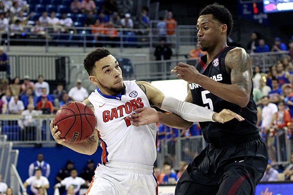 Florida guard Chris Chiozza (11) is fouled while driving to the basket by Arkansas guard Anthlon Bell (5) during the second half of an NCAA college basketball game at the O'Connell Center on Wednesday, Feb. 3, 2016 in Gainesville, Fla. Florida defeated Arkansas 87-83. (Matt Stamey/The Gainesville Sun via AP)