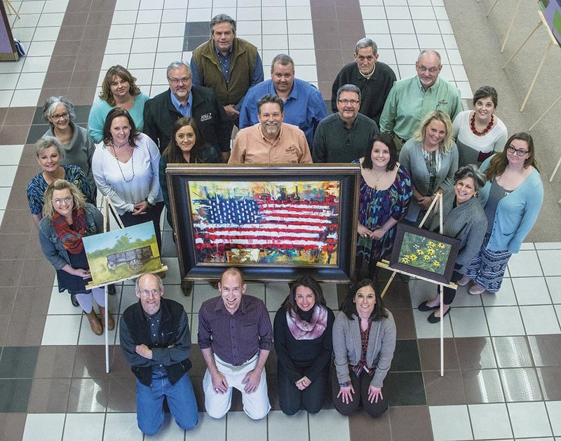 Board members for the Delta Visual Art Show pose with some of the donated art from artists who will attend the event. In the front row, kneeling, from left, are Thompson Murray, Jimmy Walker, Rebecca Pearrow and Sara Michael. Standing are Lindsey McClellan, front left by the easel; first full row, from left, Debra Jackson, Lindley Pettie, Kristen Weatherford, Jon Chadwell, Calli Chadwell, and Lee Scoggins; second row, Sharla Chalfant, Tonia Hutchinson, Robert Summers, Daniel Larson, Jeff Phillips, Tara Salinas and Tonya Ryals; and third row, Ward Massey, Frank Plegge, David Stewart and Irina Reynolds.