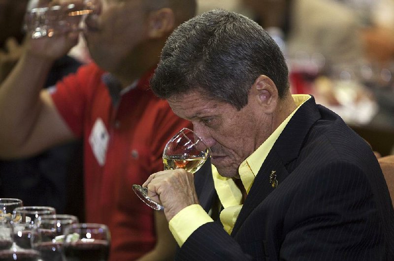 Fernando Fernandez, Cuban master of cigar sommeliers, smells a glass of wine during the first California Wine Symposium in Havana, Cuba, earlier this month. 