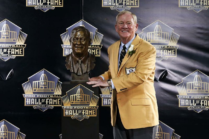 In this Saturday, Aug. 8, 2015 file photo, former President and General Manager of the Indianapolis Colts Bill Polian poses with his bust during an induction ceremony at the Pro Football Hall of Fame in Canton, Ohio. Bill Polian entered the Pro Football Hall of Fame last year, making one of the most dynamic speeches heard at the Canton shrine. This year, Polian has nearly as strong a connection to the hall. Four of the finalists for the class of 2016 have major ties to him, Friday, Feb. 5, 2016. 