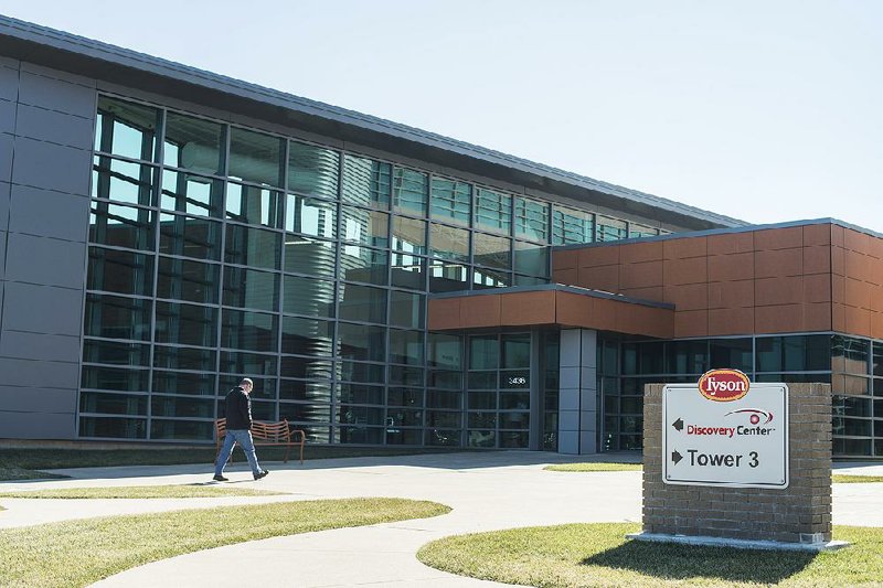 A man heads toward the entrance of Tyson Foods on Friday. The company is forecasting a record profit for the year.