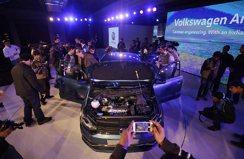 People look at a Volkswagen Ameo sedan displayed earlier this week at the Auto Expo in New Delhi. One analyst called Volkswagen’s delay on releasing quarterly earnings “an unusual step.”