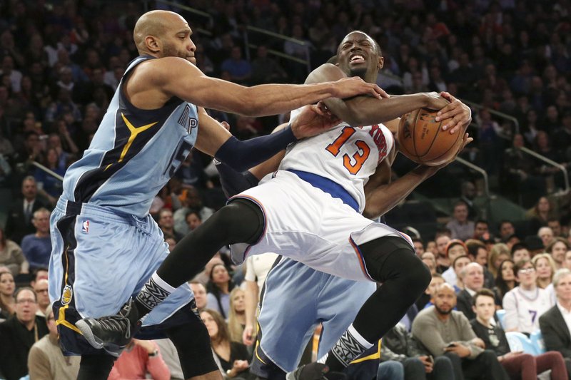 Memphis Grizzlies guard Vince Carter (left) and guard Mike Conley (in background) stop New York Knicks’ Jerian Grant (13) from going to the basket Friday during their game at Madison Square Garden in New York. 