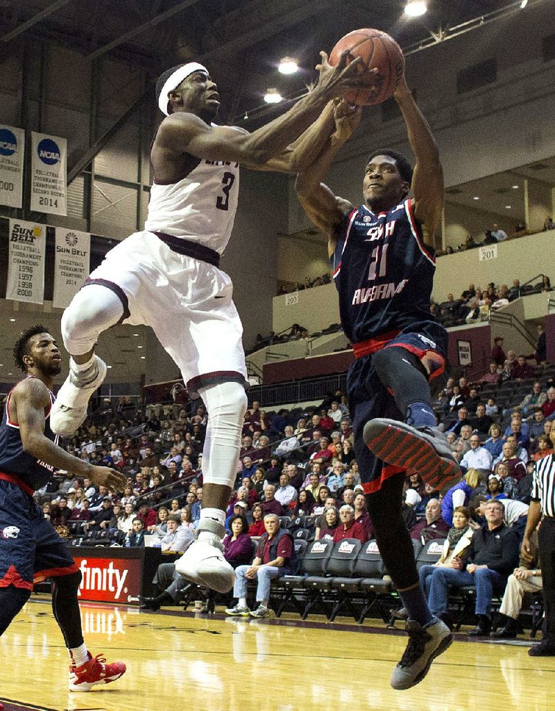 UALR’s Josh Hagins (3) fights for a rebound with South Alabama’s Nick Davis during the Trojans’ 74-43 victory over the Jaguars on Saturday at the Jack Stephens Center in Little Rock. More photos available online at arkansasonline.com/galleries.