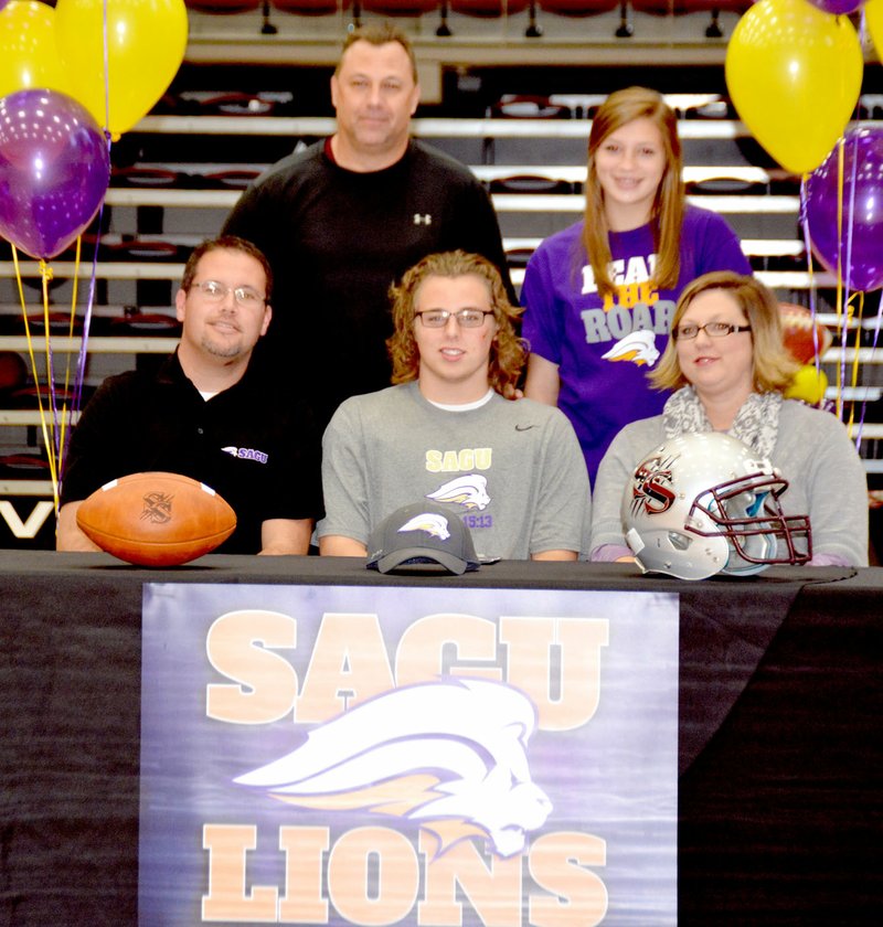 Graham Thomas/Siloam Sunday Siloam Springs senior Coby Roach signed a letter of intent to play football at Southwestern Assemblies of God (Texas). Pictured are father Jacob Roach, Coby Roach and mother Audrey Roach; back, Siloam Springs head football coach Bryan Ross and sister Alexis Roach.