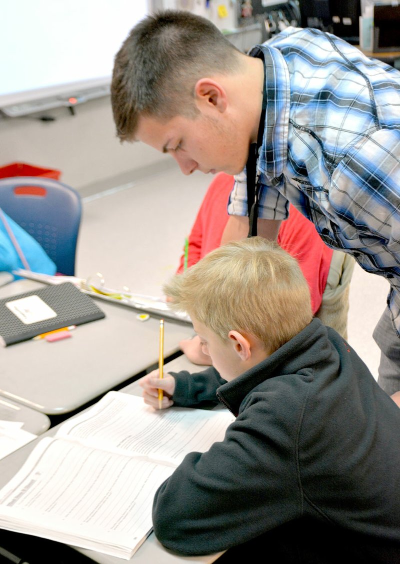 Janelle Jessen/Siloam Sunday Senior football player Chase Womack helped a fifth-grade student with a question on Thursday.