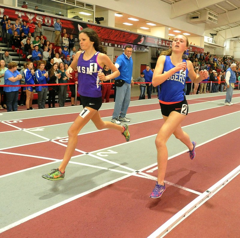 Lisa Lauschke of Rogers High (right) and Alex Ritchey of Mount St. Mary’s cross the line Saturday to finish first and second in the girls 1,600-meter run during the 5A-7A state indoor track meet at the Tyson Indoor Sports Complex in Fayetteville.