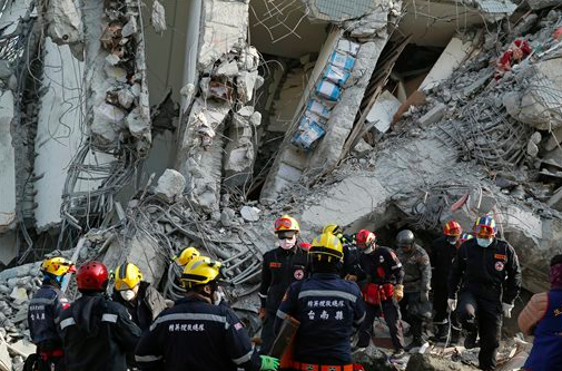 Rescuers continue to search for missing people Sunday, Feb. 7, 2016, in a building that collapsed from an earthquake in Tainan, Taiwan. 