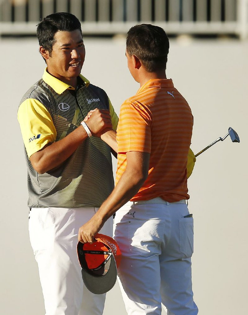 Hideki Matsuyama (left) shakes hands with Rickie Fowler on Sunday after defeating Fowler on the fourth playoff hole to win the Phoenix Open.
