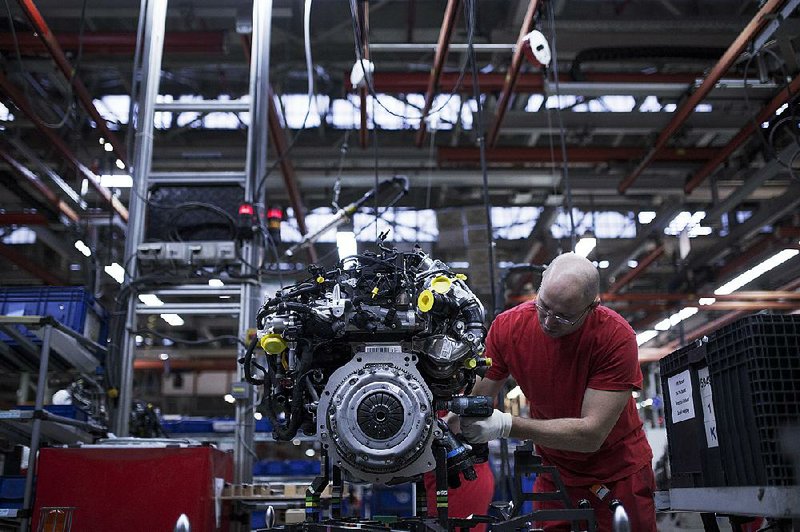 A worker prepares a new turbo diesel engine for fitting to a Volkswagen AG Caddy van on the production line at the VW plant in Poznan, Poland, in December. 