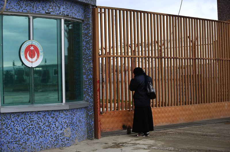 A Syrian woman stands Sunday at the closed border crossing at Kilis in southeastern Turkey and asks if it will reopen. The governor of Kilis province said the gates would stay closed barring an “extraordinary crisis.” 