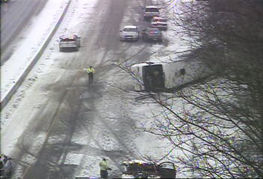 In this image from a Connecticut Department of Transportation traffic camera, a bus lies on the shoulder of northbound Interstate 95 on Monday, Feb. 8, 2016, in Madison, Conn. 
