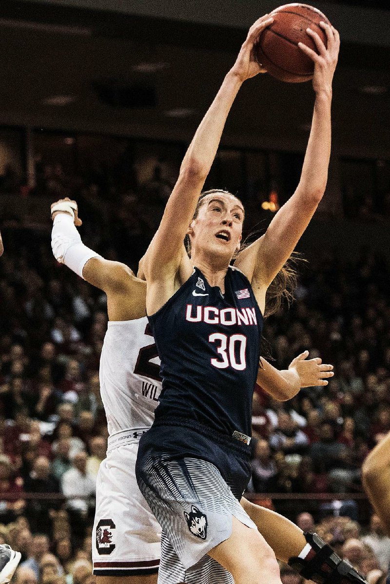 Connecticut’s Breanna Stewart (30) grabs one of her 10 rebounds against No. 2 South Carolina on Monday night in Columbia, S.C. Stewart added 25 points and fi ve blocks as the top-ranked Huskies held off a late rally to win their 60th game in a row while putting an end to the Gamecocks’ 45-game home winning streak.