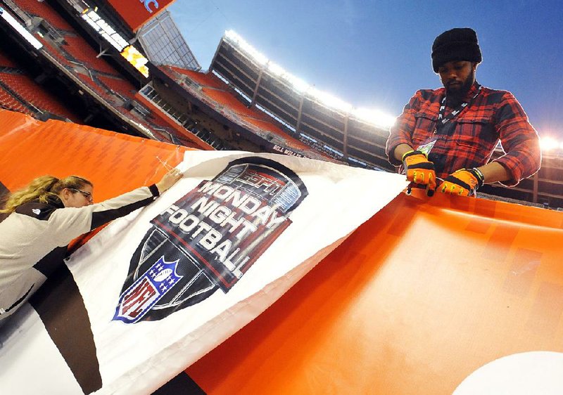 Workers in Cleveland install an ESPN Monday Night Football banner before an NFL game between the Cleveland Browns and the Baltimore Ravens in November. A drop in cable-television subscriptions that include ESPN channels is taking a toll on The Walt Disney Co. 