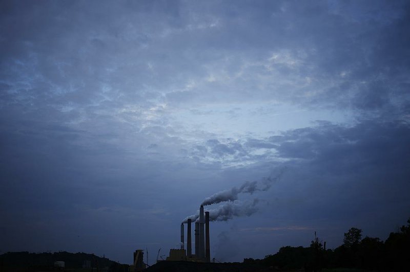 Emissions stream from the coal-fired Ghent Generating Station near Ghent, Ky., in this 2014 photo. The U.S. Supreme Court, acting on an appeal from utilities, coal miners and 27 states, including Arkansas, has delayed a federal regulation that would cut emissions.