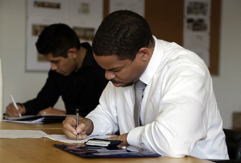 People complete applications last month at a job fair sponsored by The Genuine Hospitality Group in Miami. The number of U.S. job openings rose in December to 5.6 million, the Labor Department said Tuesday. 