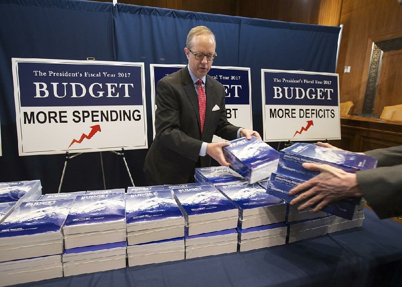 Eric Ueland, staff director for Senate Budget Committee Chairman Mike Enzi, R-Wyo., sets out copies of President Barack Obama’s proposed budget Tuesday on Capitol Hill in Washington.