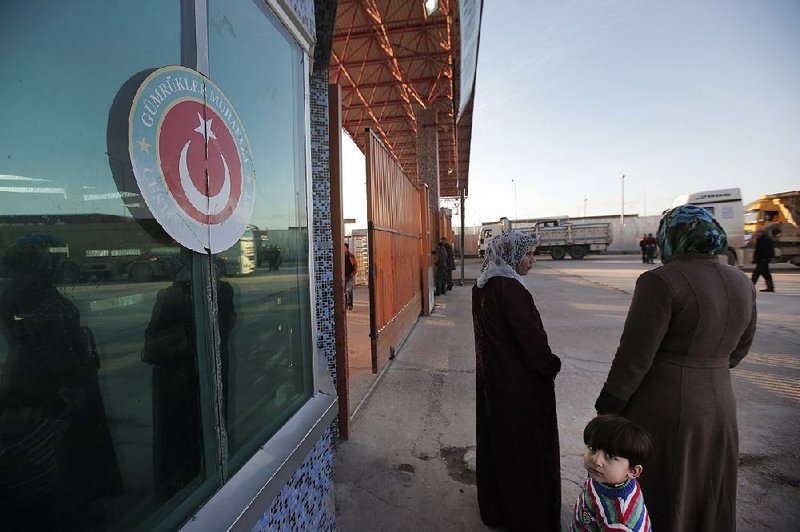 Syrians wait Tuesday at the closed border crossing on the outskirts of Kilis, a town in southeastern Turkey. 