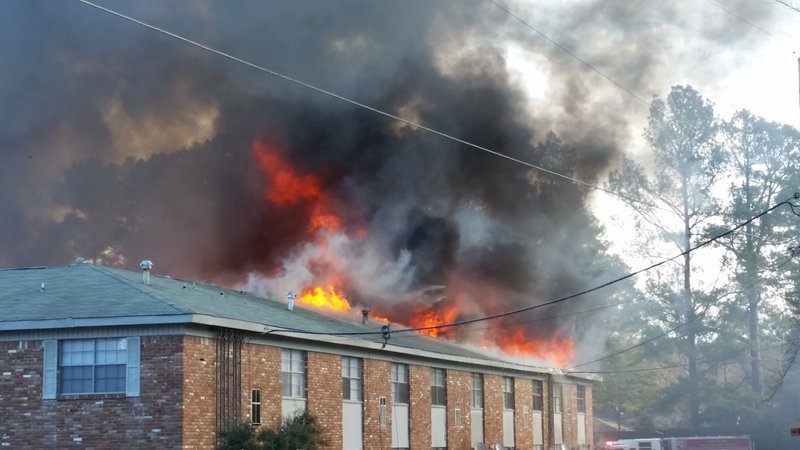 Flames shoot through the roof of Country Club Plaza apartments Wednesday morning in Pine Bluff.