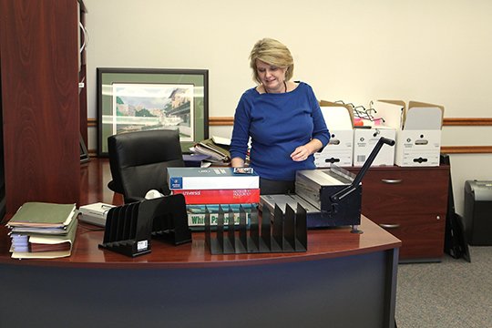 The Sentinel-Record/Richard Rasmussen SETTLING IN: County Comptroller Susan Ashmore organizes her new office in the basement of the county courthouse Tuesday. She'll be in charge of the five-person financial management office that will consolidate most of the county's financial responsibilities into a single department.