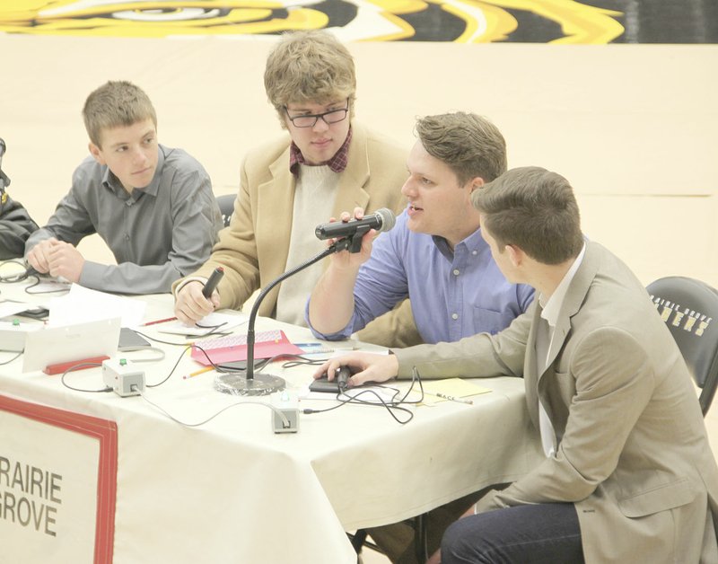 LYNN KUTTER ENTERPRISE-LEADER Micah Duncan with Prairie Grove High School Academic Competition in Education team answers a question during an ACE match last week at Tiger Arena. Others on Prairie Grove&#8217;s team include Avery Roton, left, Roy McKenzie and Spencer Parnell. Prairie Grove won its match against Shiloh Christian and Greenland and has advanced to the championship round Feb. 16 in Farmington.