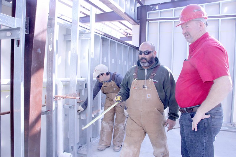 LYNN KUTTER ENTERPRISE-LEADER Marcelo Ramirez with Town &amp; Country Plumbing in Rogers discusses plumbing with Rick Bramall, Farmington building official. Ramirez and his crew are working on the new auditorium for Farmington Church of Christ on Main Street.