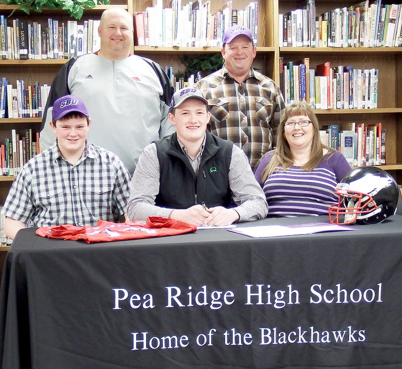 TIMES photograph by Annette Beard Blackhawk football player Brent Ferguson signed a letter of intent to play football at Southwest Baptist University in Bolivar, Mo. Gathering with fellow teammates and school peers, Ferguson&#8217;s parents, Steve and Julie Ferguson; brother (Cooper) and grandfather joined Blackhawk coaches in congratulating the senior, who said SBU filled his requirements spiritually, financially and physically. Head football coach Tony Travis congratulated Ferguson.