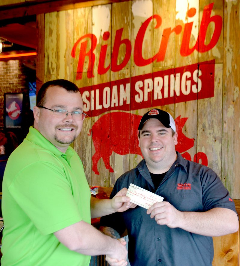 Michael Burchfiel/Herald-Leader Wayne Thomas, left, accepted a check from Rib Crib General Manager Chuck Smith. The money was raised for the charity Kind at Heart, which Thomas founded.