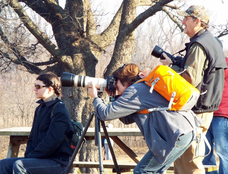 Photo by Randy Moll Arin Stephens of Fayetteville (left), Laura Singleton and Jeff Singleton, both of Bella Vista, were among those who watched for birds and other wildlife along the Eagle Watch nature trail on Saturday morning during the Northwest Arkansas Audubon Society field trip there.