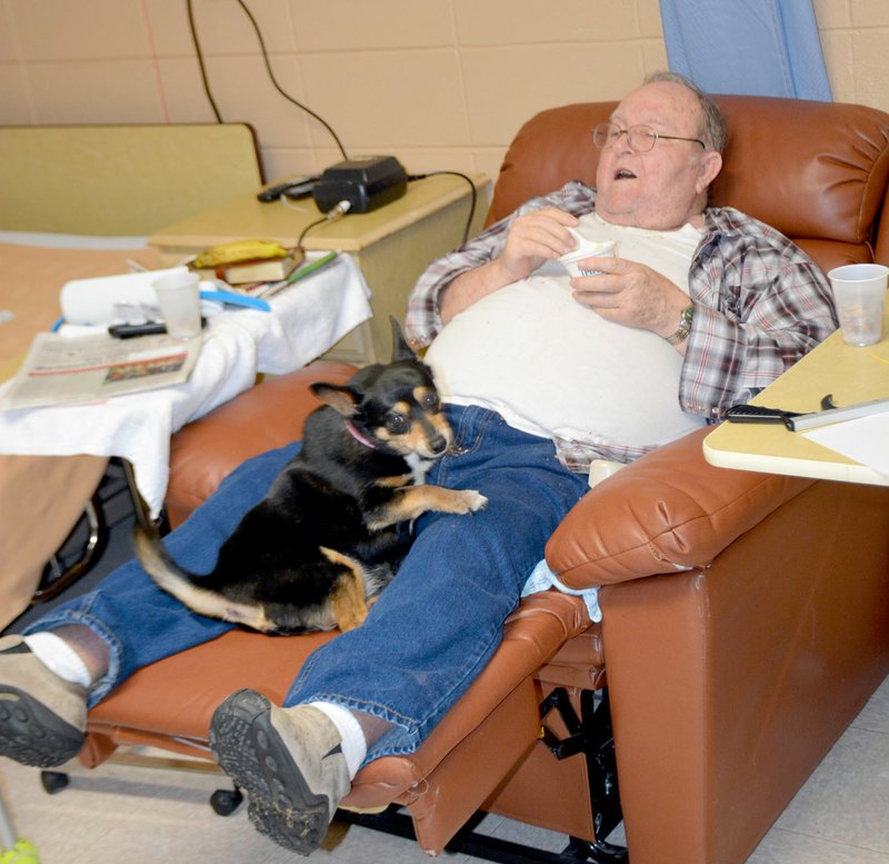 Janelle Jessen/Herald-Leader Polly sat in Lebron Vaughan&#8217;s lap as he relaxed and watched TV on Monday. Polly has been serving as the nursing home pet for the past two weeks. She comes to work each day with her owner, nurse Lindsay Anderson.