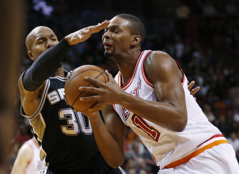 Miami Heat forward Chris Bosh (1) goes up for a shot against San Antonio Spurs forward David West (30) during the first half of an NBA basketball game, Tuesday, Feb. 9, 2016, in Miami. 