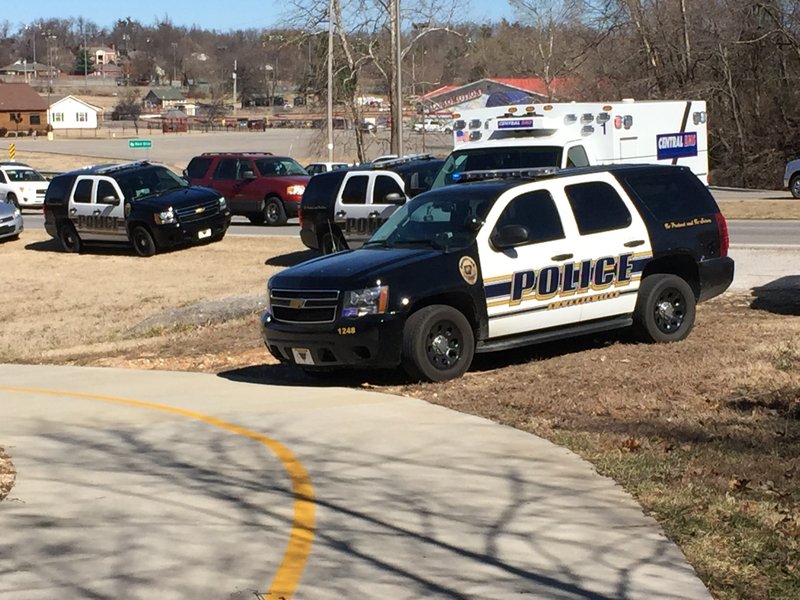 Police near where authorities said a man fell to his death from a tree crossing a creek near the Razorback Greenway.