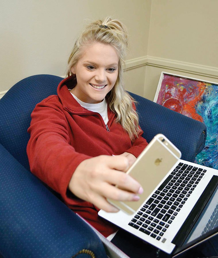 Lindsey Agerton of Vilonia, a junior at the University of Central Arkansas in Conway, takes a selfie between classes. Agerton said she didn’t realize the UCA yearbook, The Scroll, accepted selfies from students to use in its portrait section. The Scroll’s staff instituted the idea last year when portraits for the 
publication were lagging.