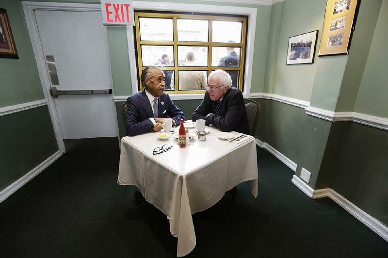 The Rev. Al Sharpton talks with Democratic presidential candidate Bernie Sanders at a breakfast meeting Wednesday at Sylvia’s Restaurant in Harlem. Former NAACP leader Benjamin Jealous, who recently endorsed Sanders, also attended the meeting.