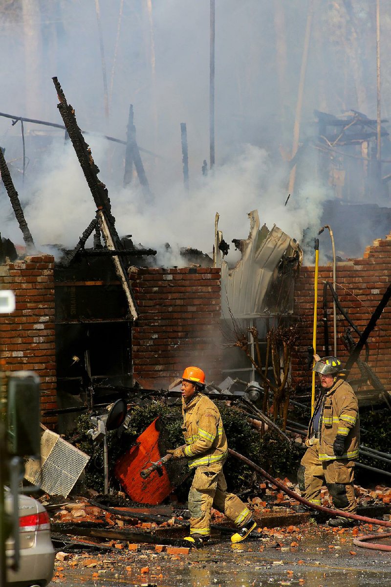 Pine Bluff firefighters battle a blaze near the rear of the two-story Country Club Plaza apartment building Wednesday in Pine Bluff. 