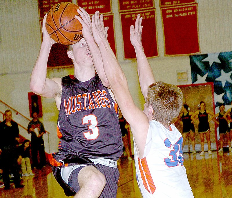 Photo by Rick Peck McDonald County&#8217;s Drew Harmon drives to the basket past East Newton&#8217;s Tyler Winsauer during the Mustangs&#8217; 47-45 win Friday night at East Newton High School. Harmon&#x2019;s jumper with under five seconds left lifted the Mustangs to their 17th win of the season.